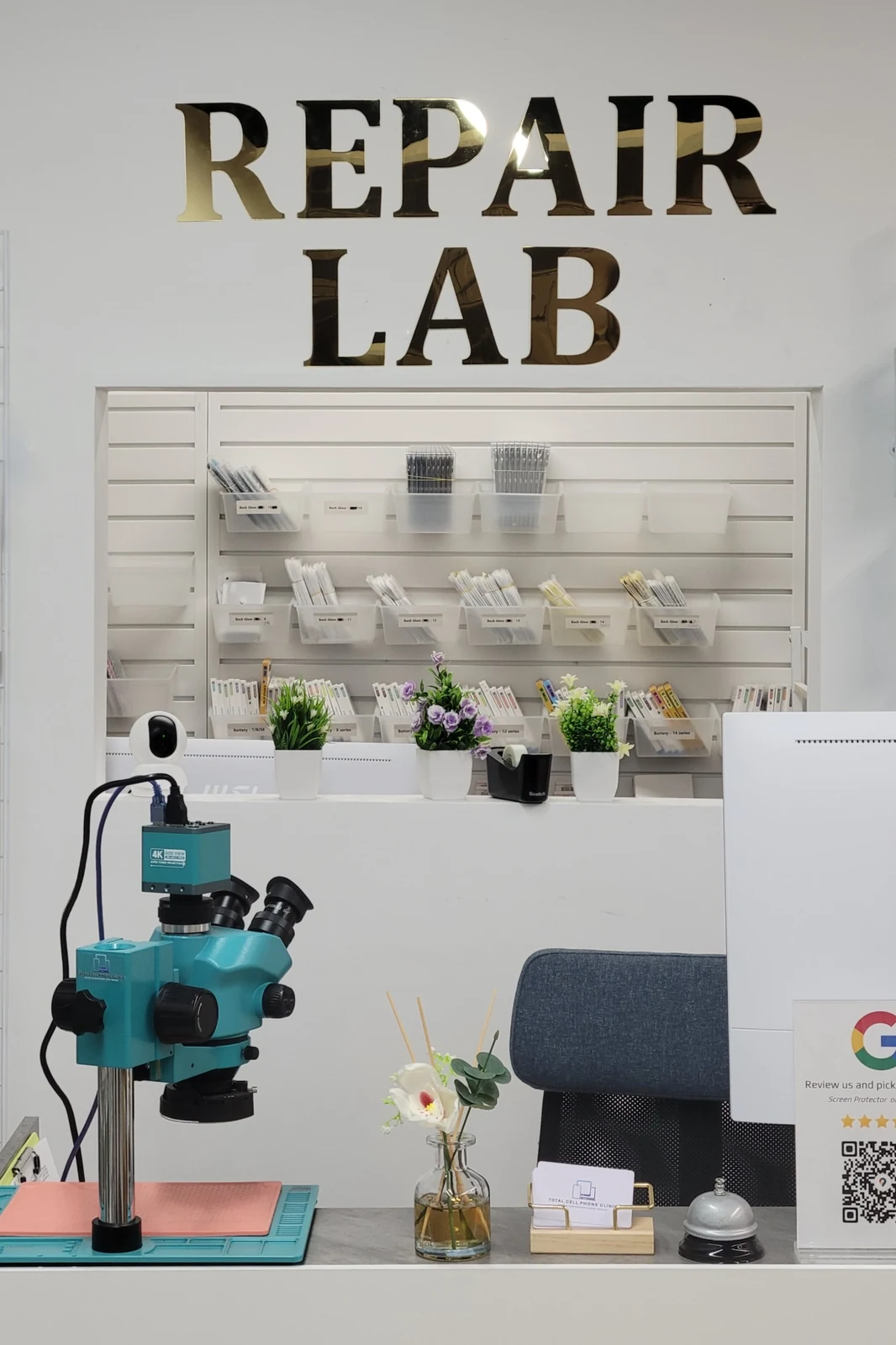 TCPC repair lab counter with microscope and organized parts wall